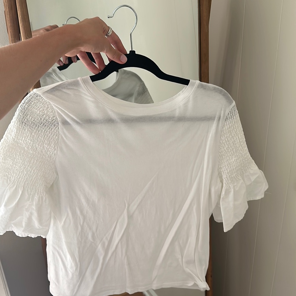 White top with frilled sleeves size M.